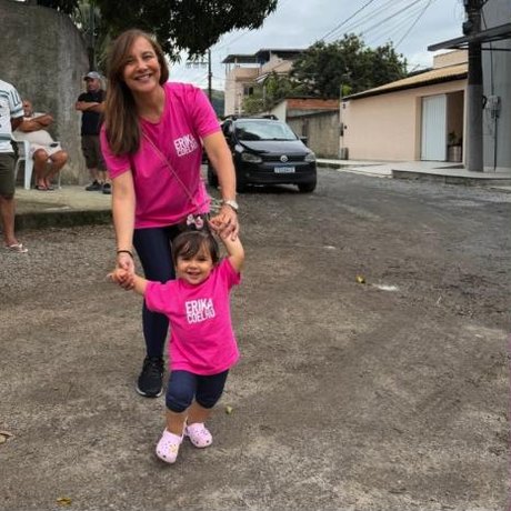 Erika Coelho caminhando com a filha Lis em uma rua da Zona Oeste